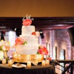 Three Tiered, Round White Wedding Cake with Coral Flower Accents