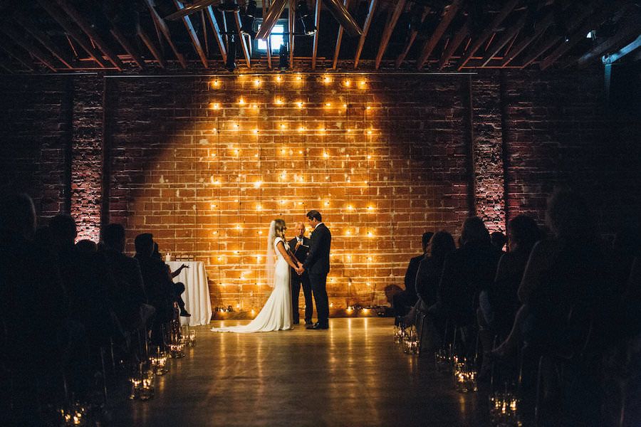 Modern, Industrial Wedding Ceremony with Lighted Backdrop and Brick Wall | St. Pete Wedding Venue NOVA 535