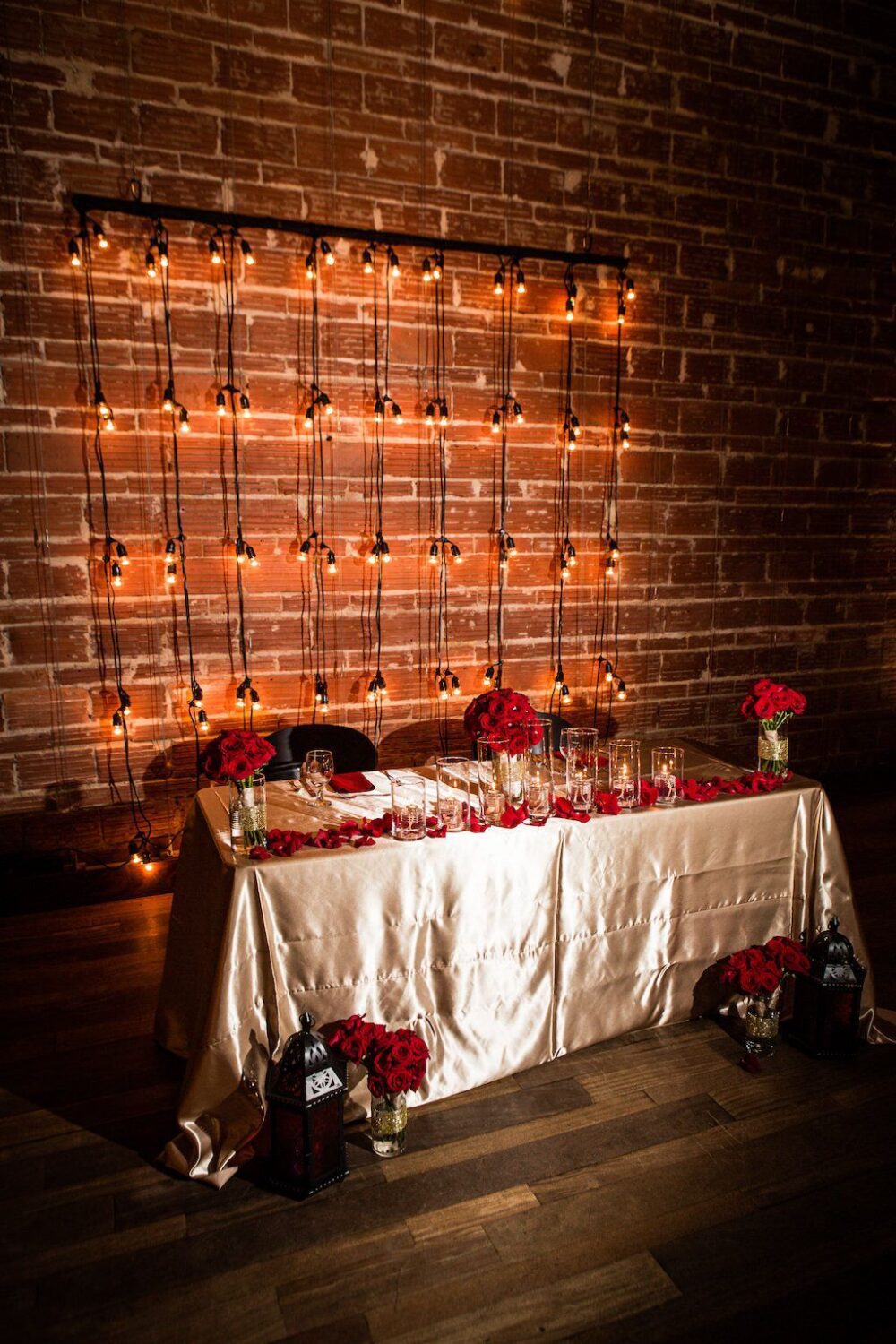 Glam red and gold sweetheart table with string light backdrop at St. Pete wedding venue NOVA 535