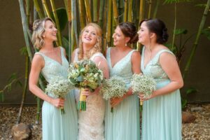 Bridesmaids in long v-neck seafoam green dresses at St. Pete wedding venue NOVA 535