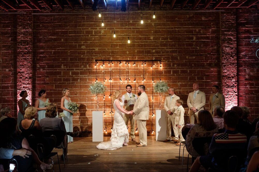 Industrial wedding ceremony with string light backdrop in downtown St. Pete at NOVA 535