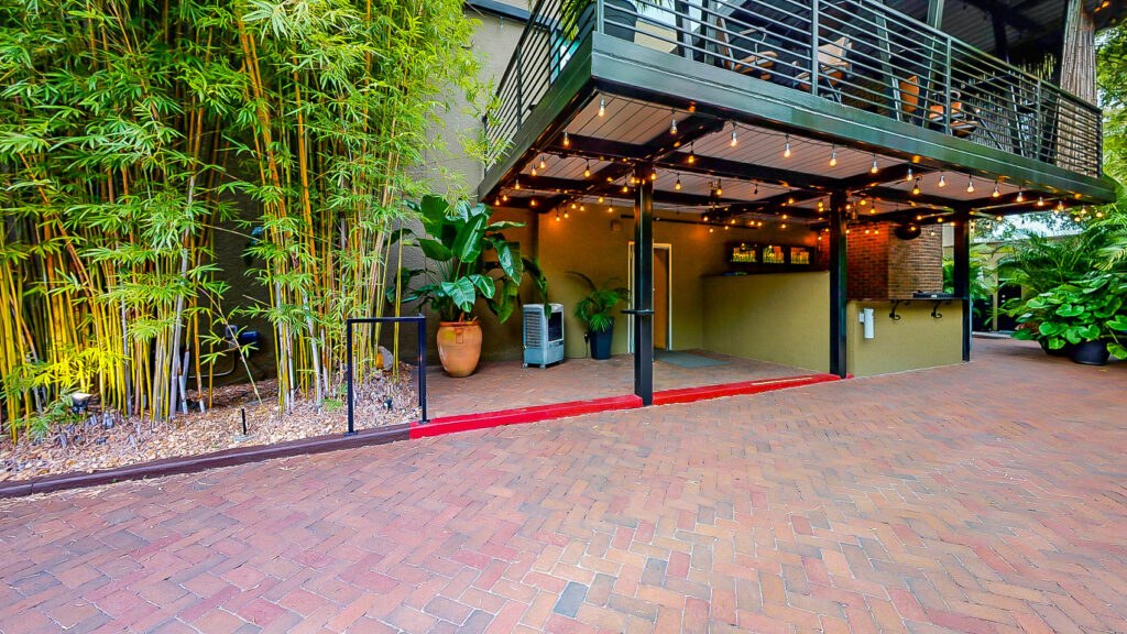 private, Lush brick and bamboo courtyard at downtown St. Pete, Florida historic wedding venue and unique events space NOVA 535 - facing north onto courtyard bar and upstairs balcony