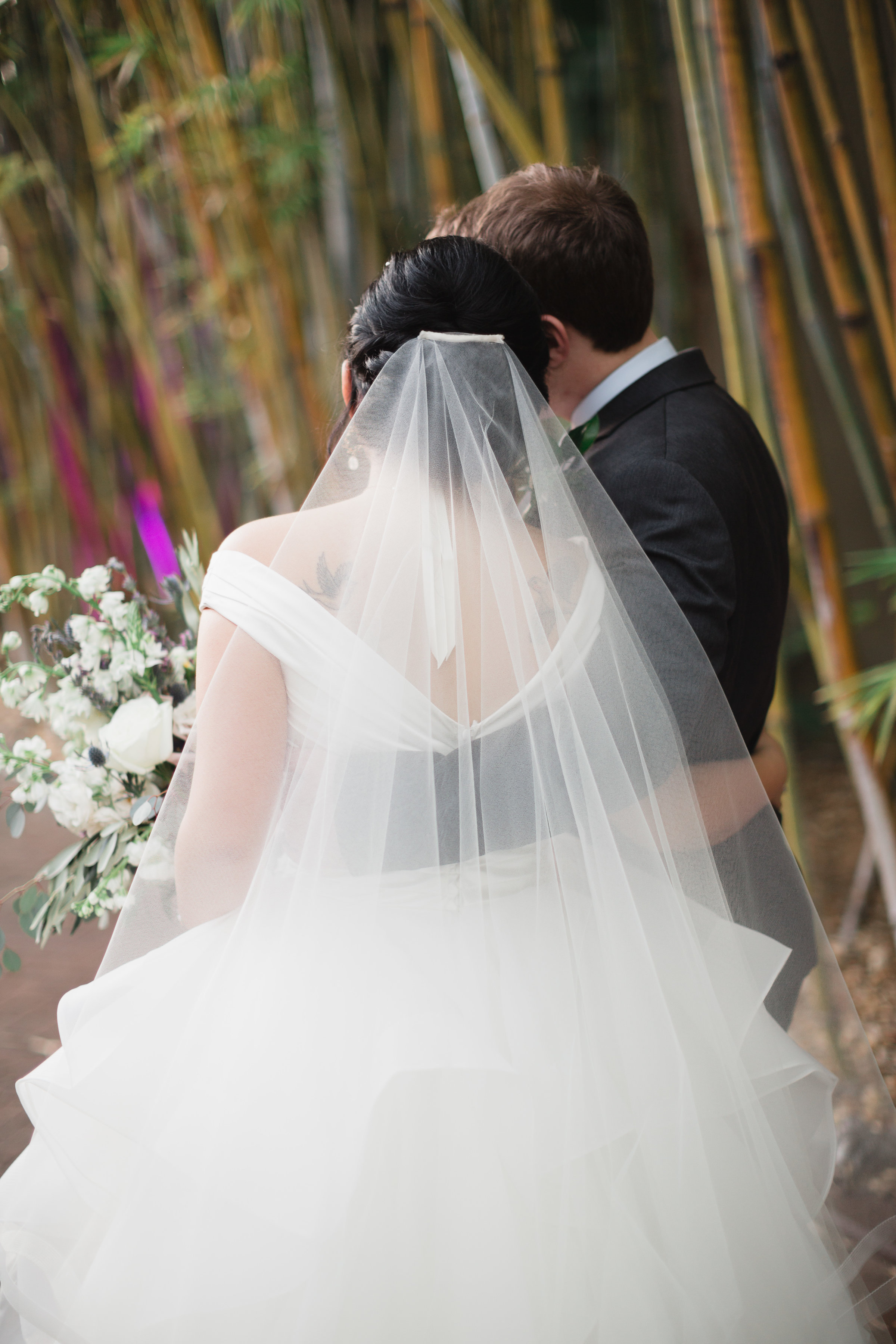 Bride in veil with groom in bamboo gardens at NOVA 535