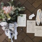 Tan and black wedding invitations with protea bouquet